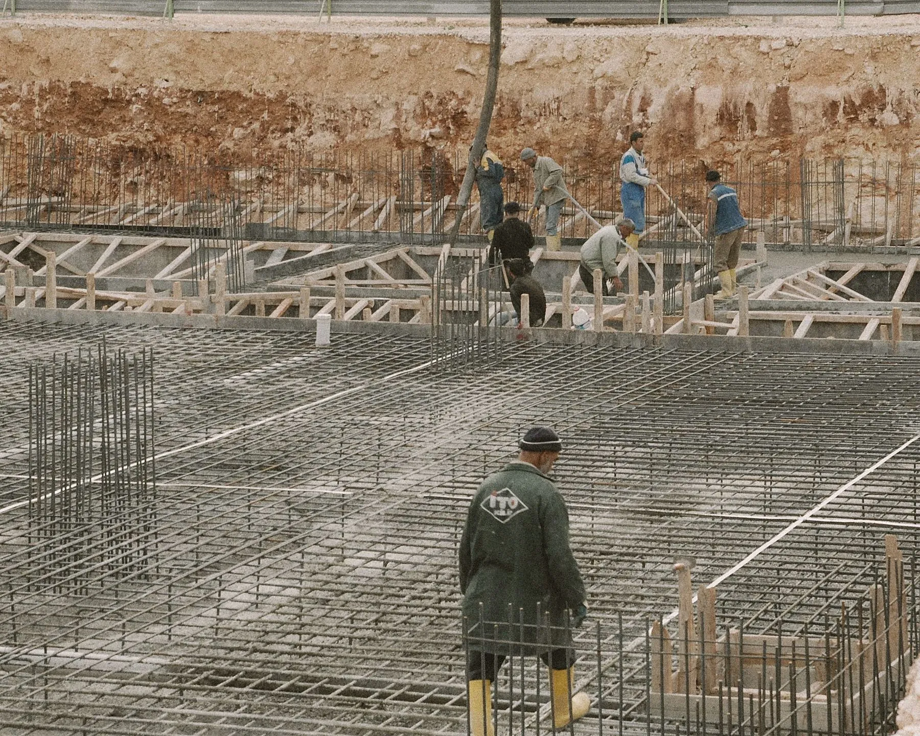 Crew placing concrete on a reinforced foundation slab